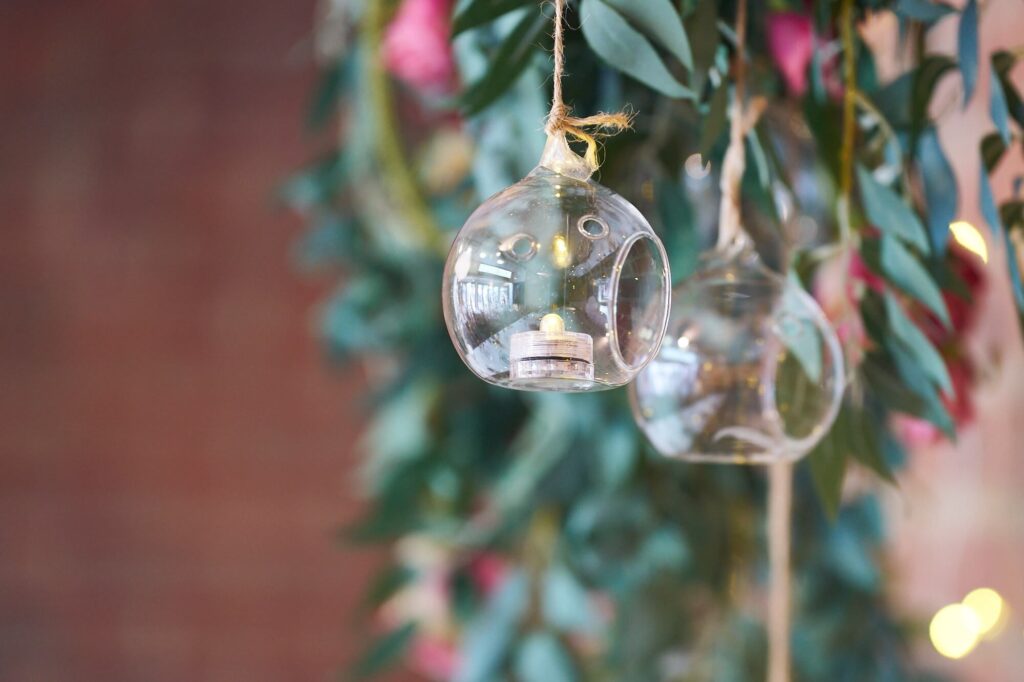 Elegant Clifton Park wedding venue decor with hanging tealight baubles on the arch.
