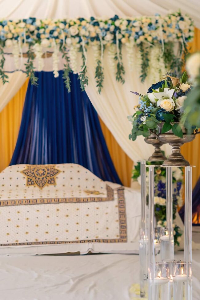 Wedding canopy backdrop with white draping and blue and gold details
