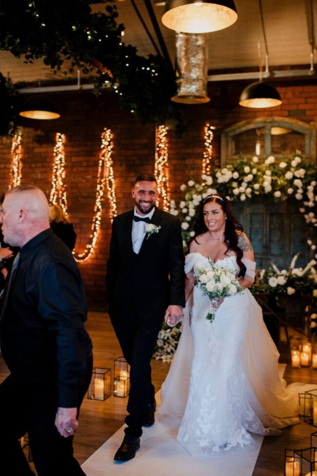 White wedding aisle runner with bride and groom at an indoor wedding venue