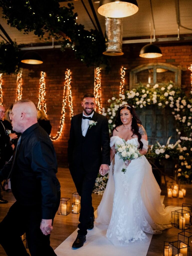 White wedding aisle runner with bride and groom at an indoor wedding venue