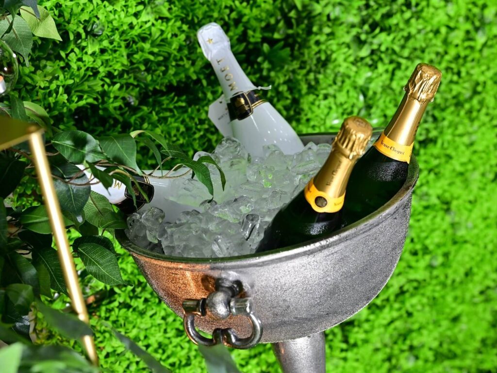 Large silver champagne bowl filled with ice and bottles of champagne