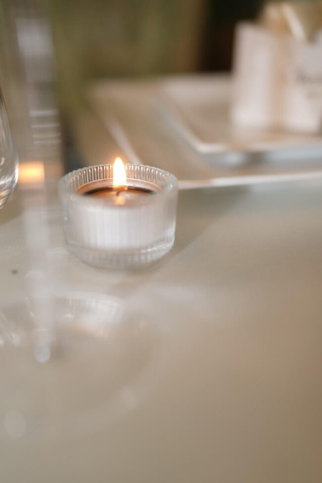 Clear ribbed tealight holder with vertical glass detailing and candlelight