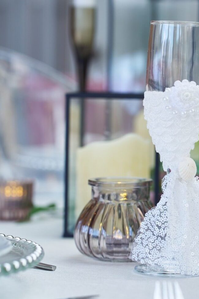 Smoke grey tealight holder beside a lantern and wedding table setting