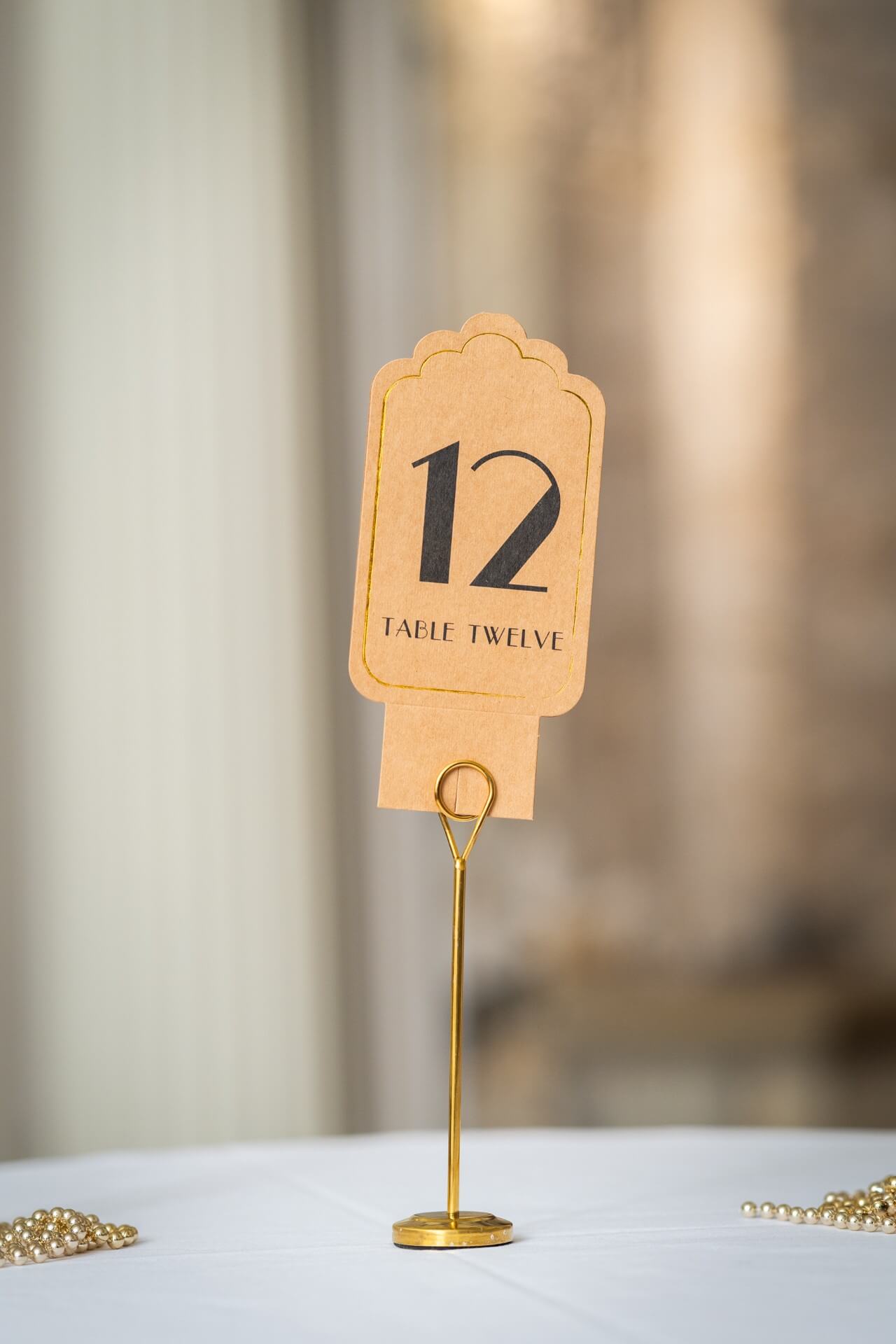 Gold table number stand with round base and loop holder