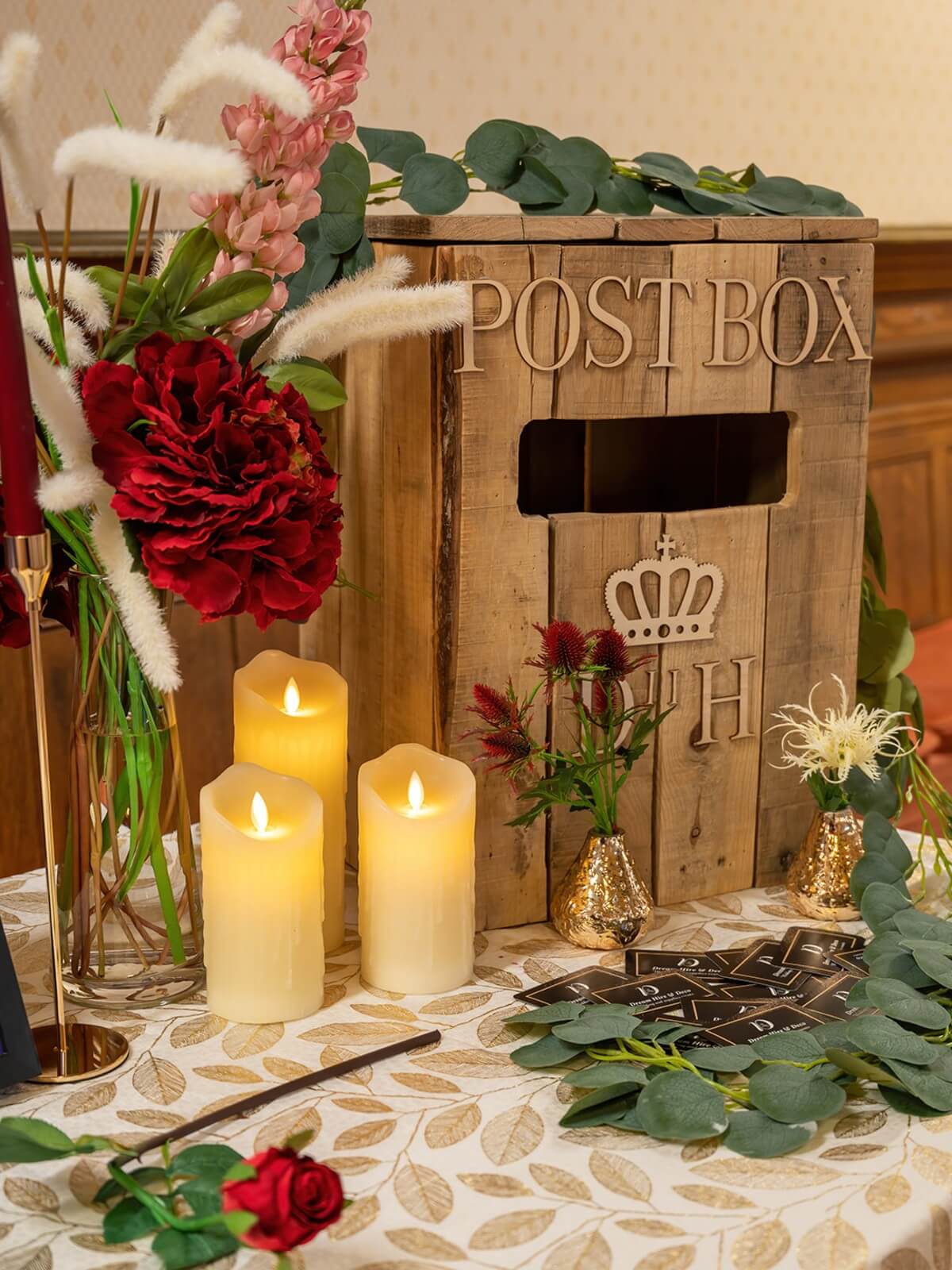 Wooden wedding post box styled with candles and florals on a gift table