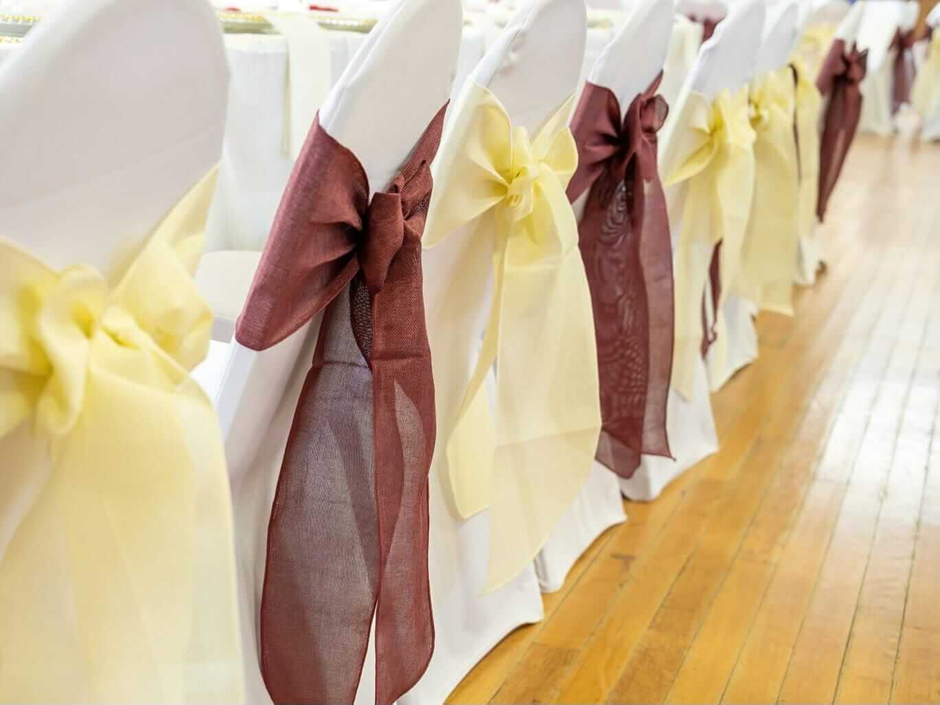 Sash chair covers with cream and burgundy fabric sashes