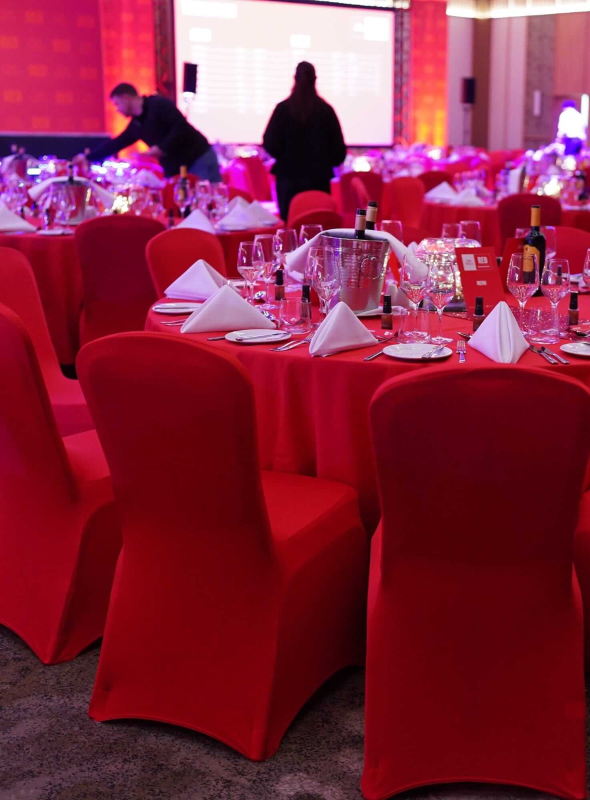 Red chair covers for hire around event tables