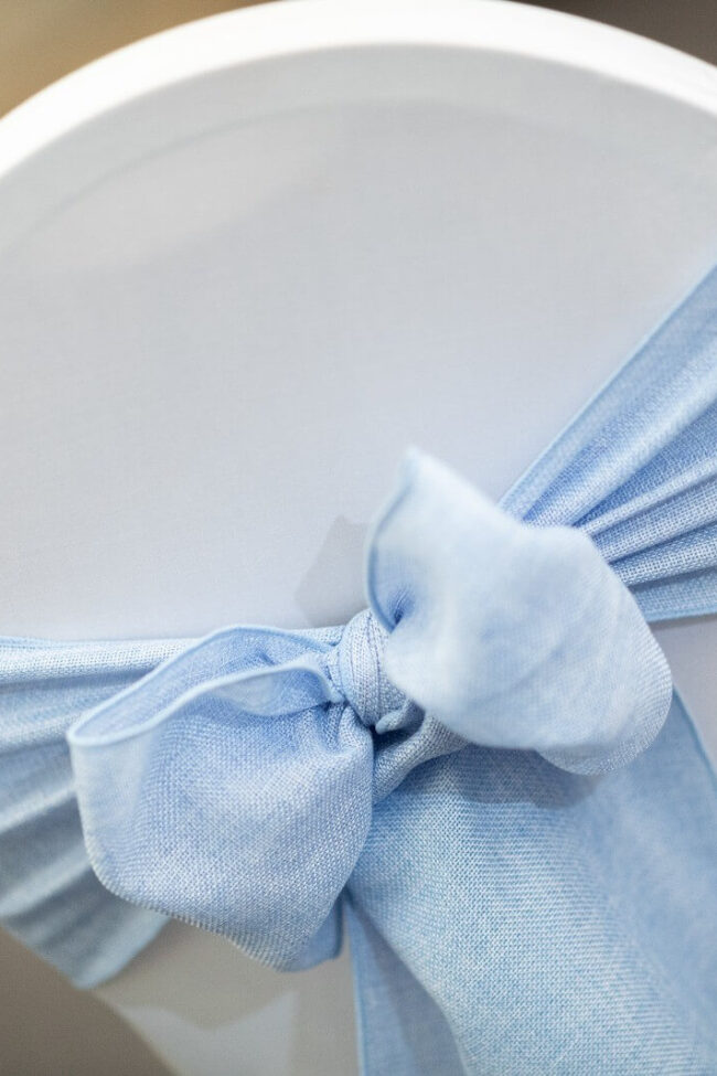 Close-up of a baby blue burlap chair sash bow