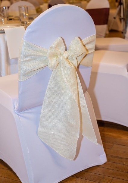 Venue chair cover styled with a chair sash tied in a bow