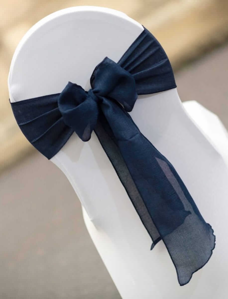 Navy chair sashes tied in a bow on a white chair cover