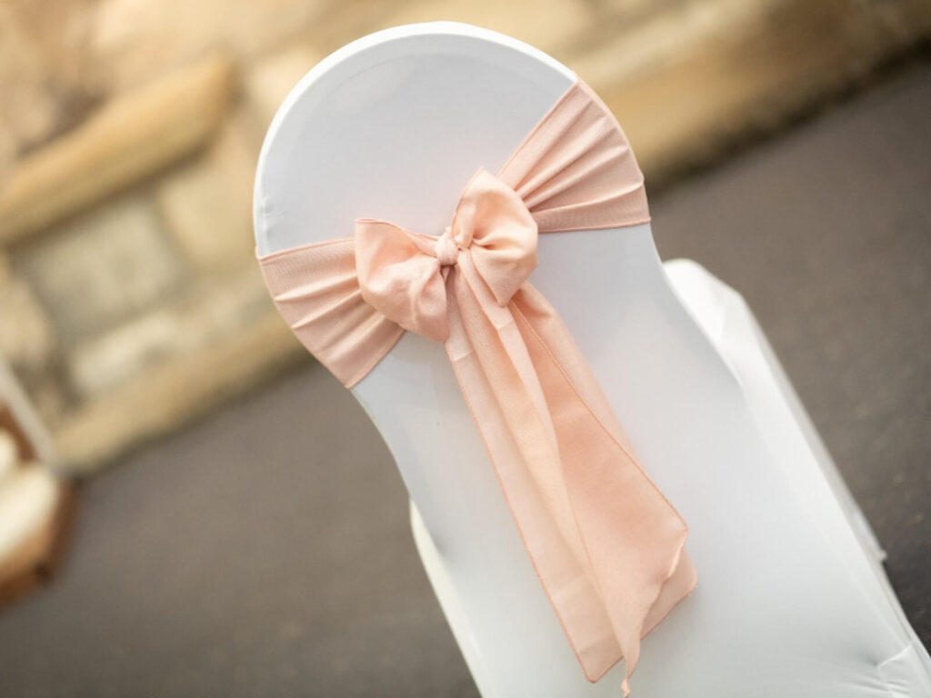 Blush pink burlap chair sash tied in a soft bow
