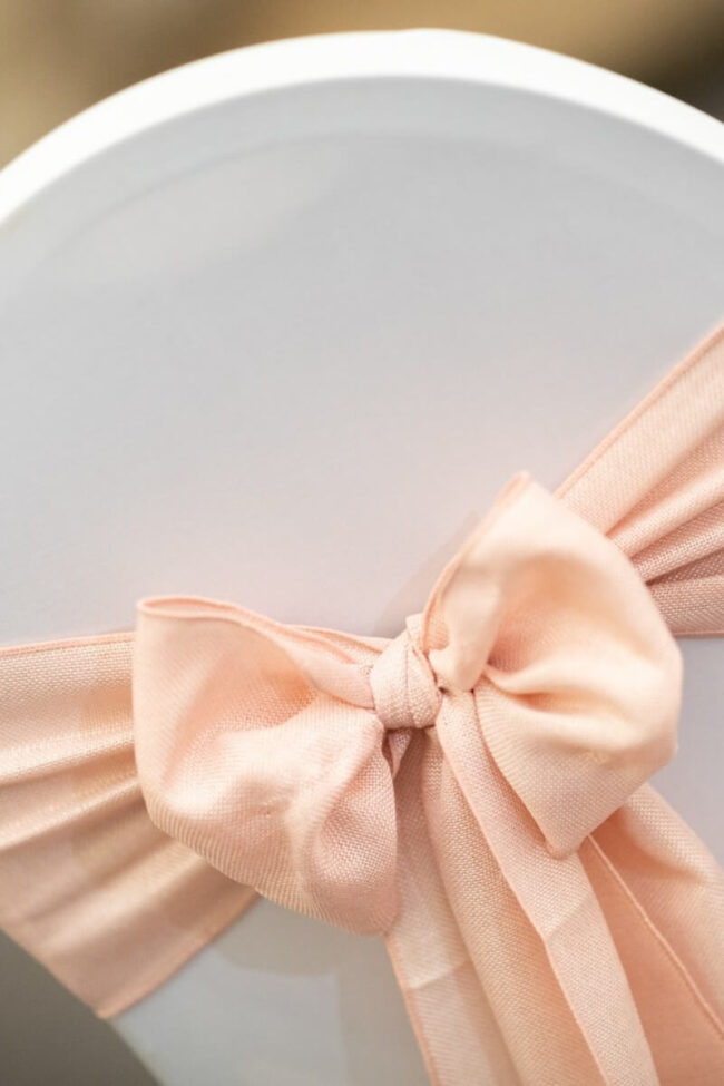 Close-up of a pink burlap chair sash bow