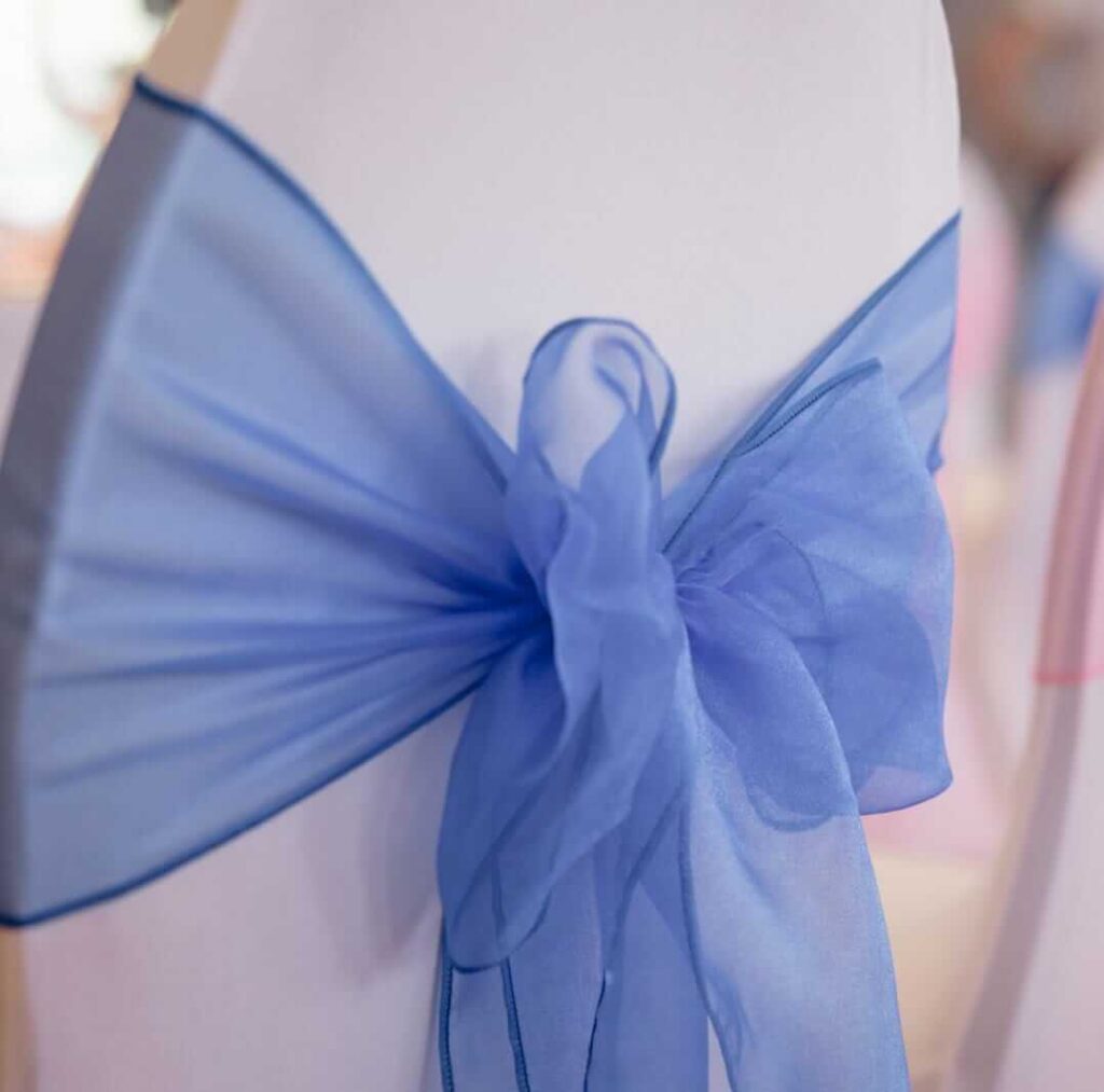 Royal blue sashes tied in a bow on a white chair cover