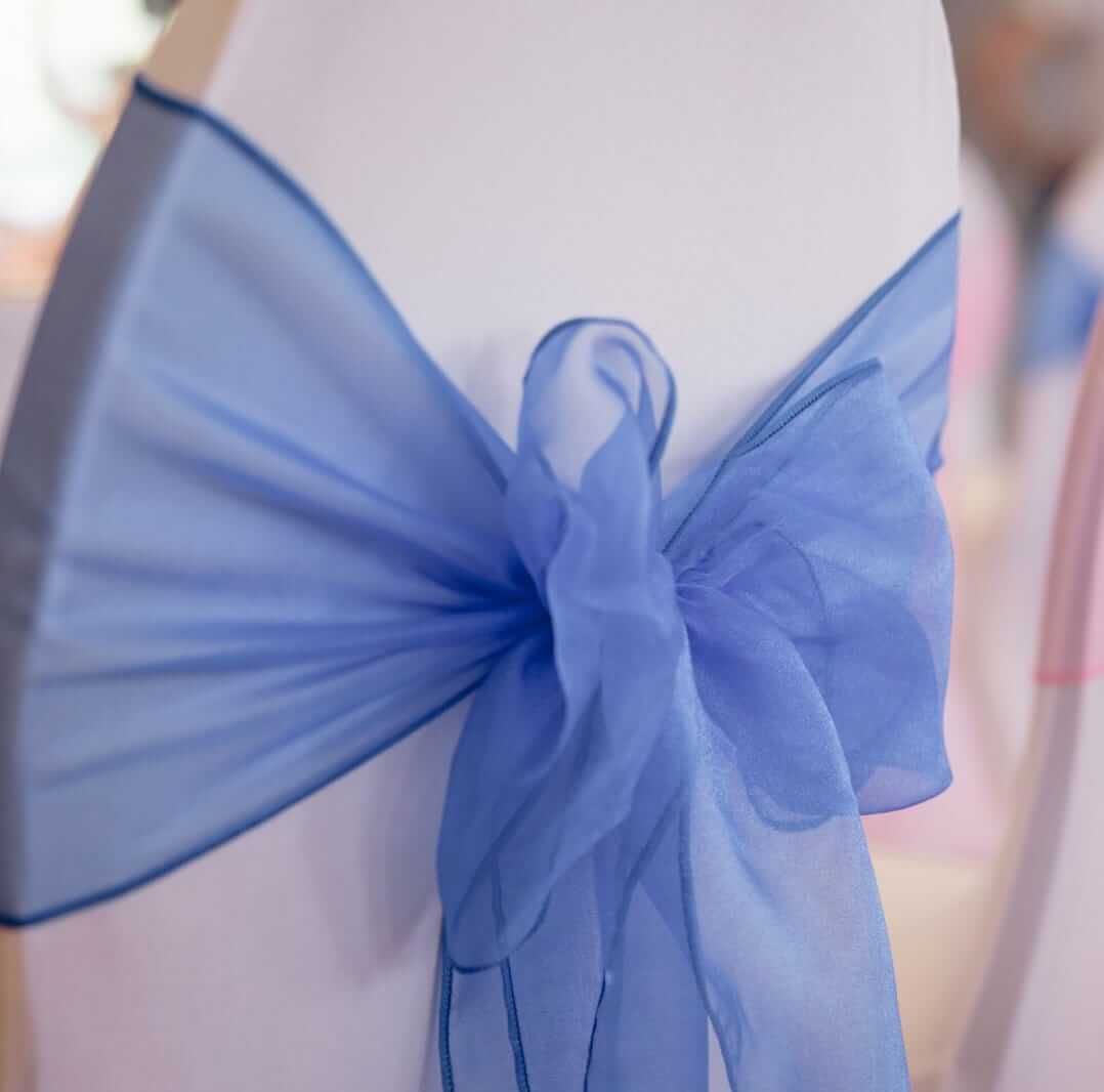 Royal blue sashes tied in a bow on a white chair cover