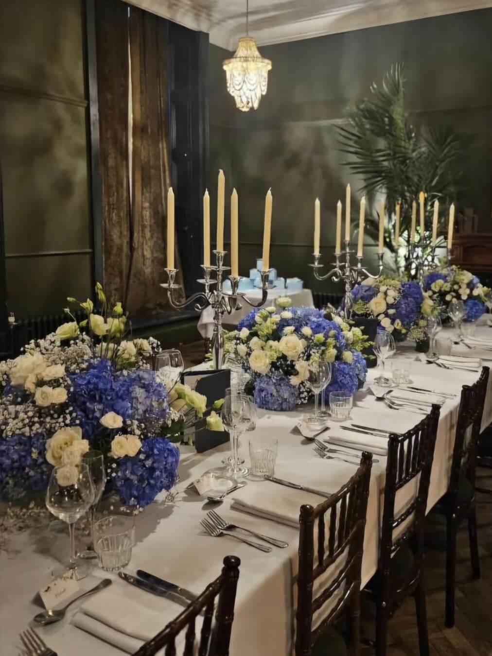 party table decorations with blue and white florals and candelabras