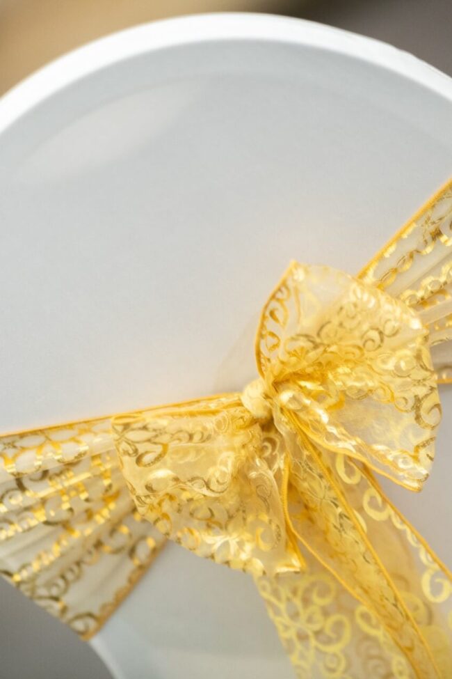 Gold organza chair sash tied in a decorative bow
