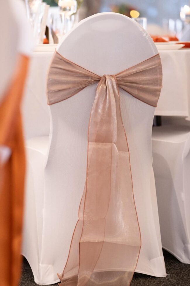 Burlwood silk sashes tied in a bow on a white chair cover