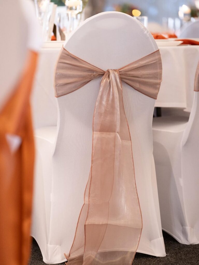 Burlwood silk sashes tied in a bow on a white chair cover