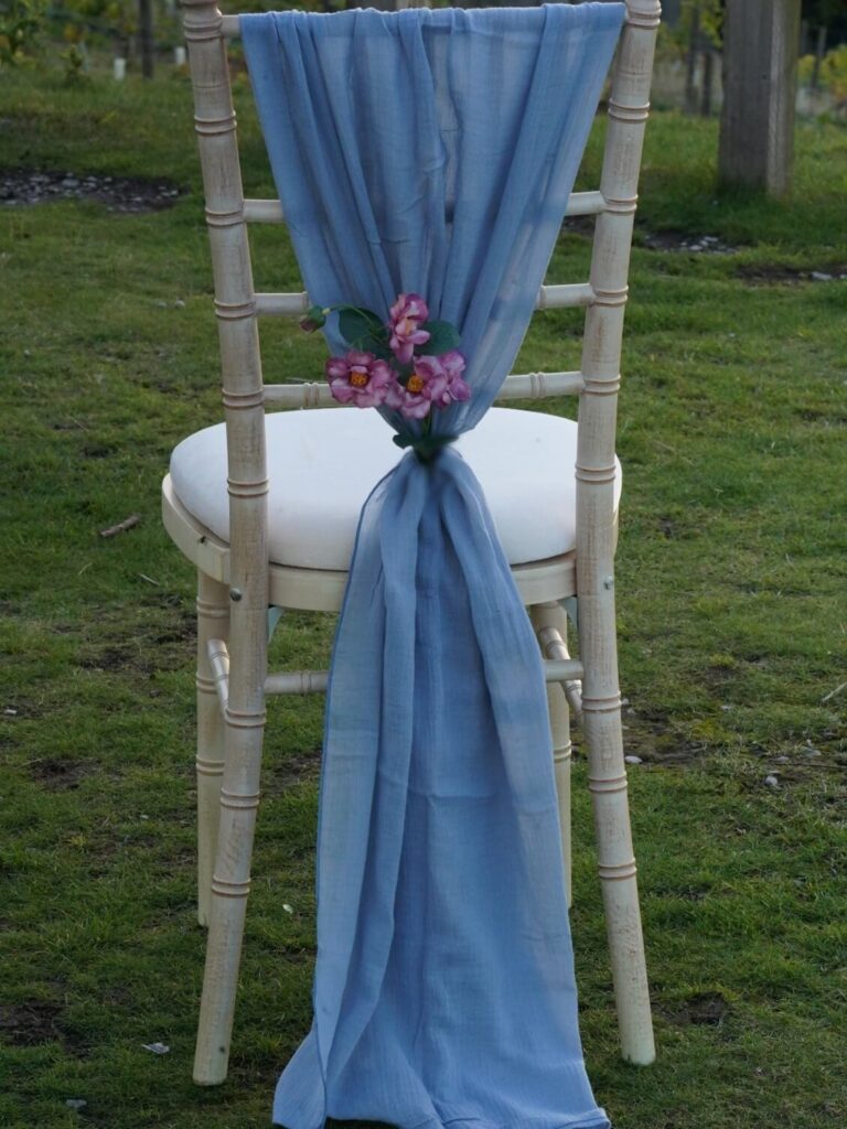 Blue chair drapes in dusty blue styled as a vertical drop on a chiavari chair