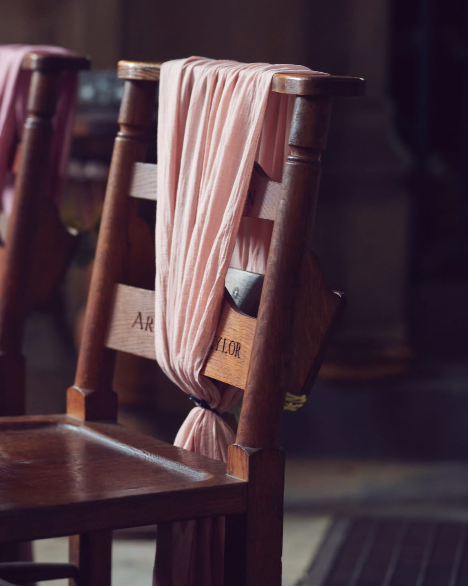 Blush pink cheesecloth chair drape styled over a wooden chair