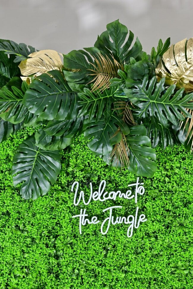 Foliage wall styled with tropical leaves and gold accents