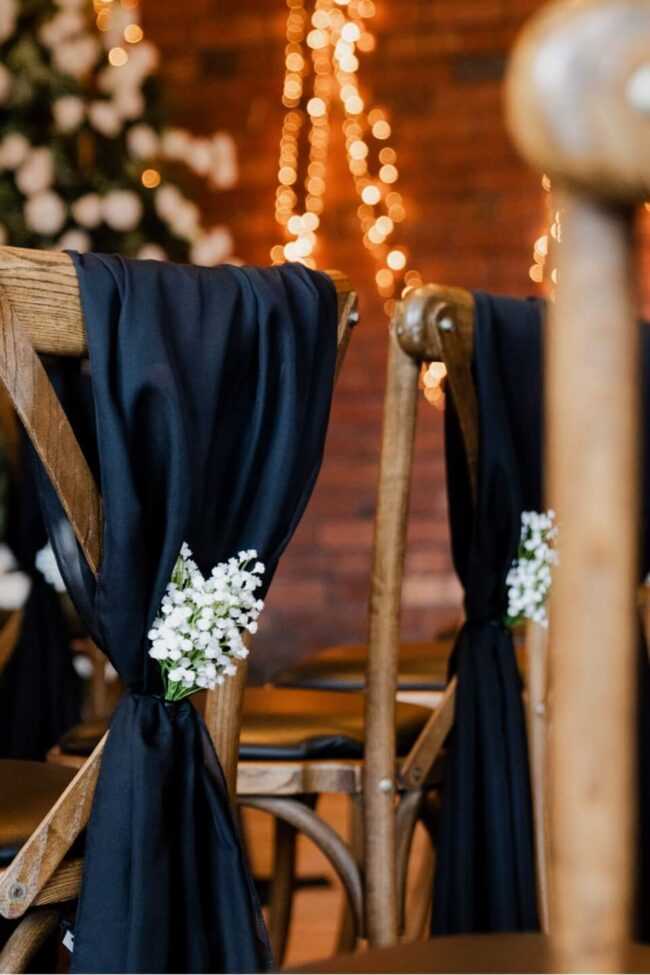 Black chiffon chair drapes for hire styled on wooden chairs