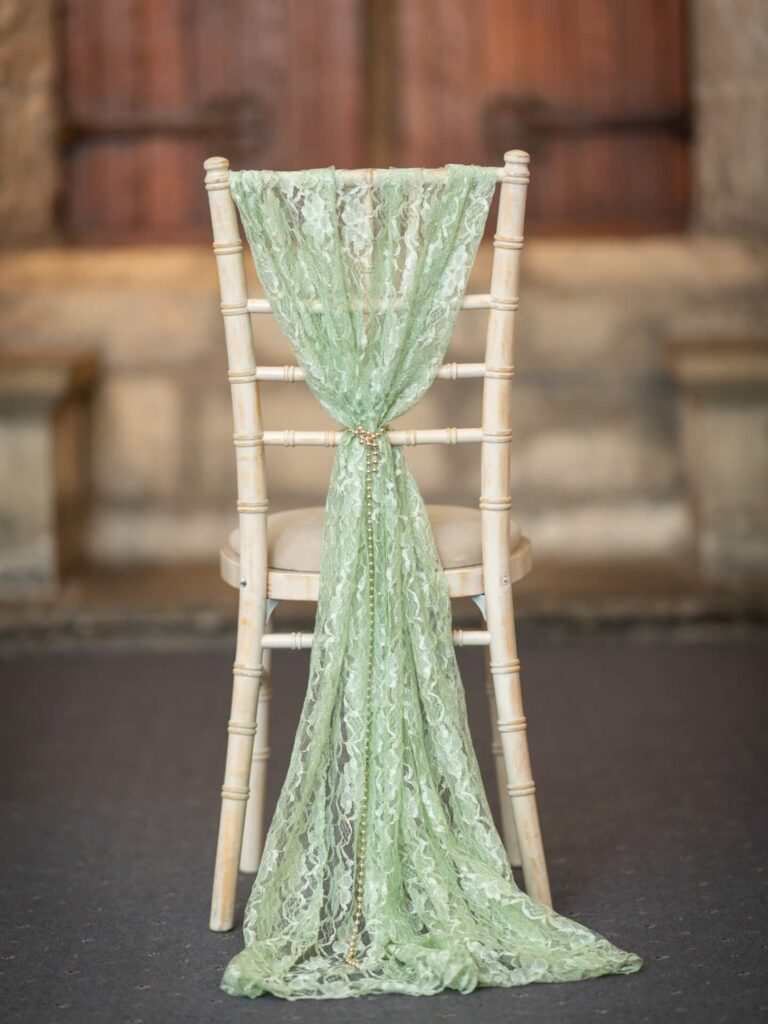 Sage drape styled as a lace vertical drop on a chiavari chair