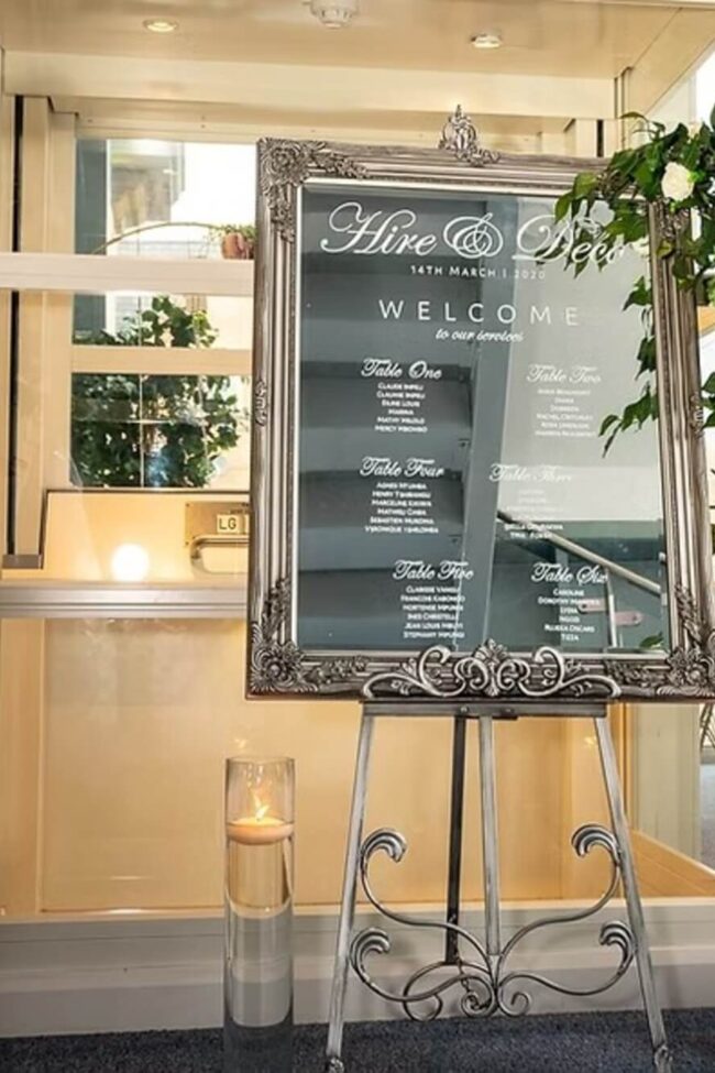 Mirror sign display on a silver antique French easel at a venue entrance