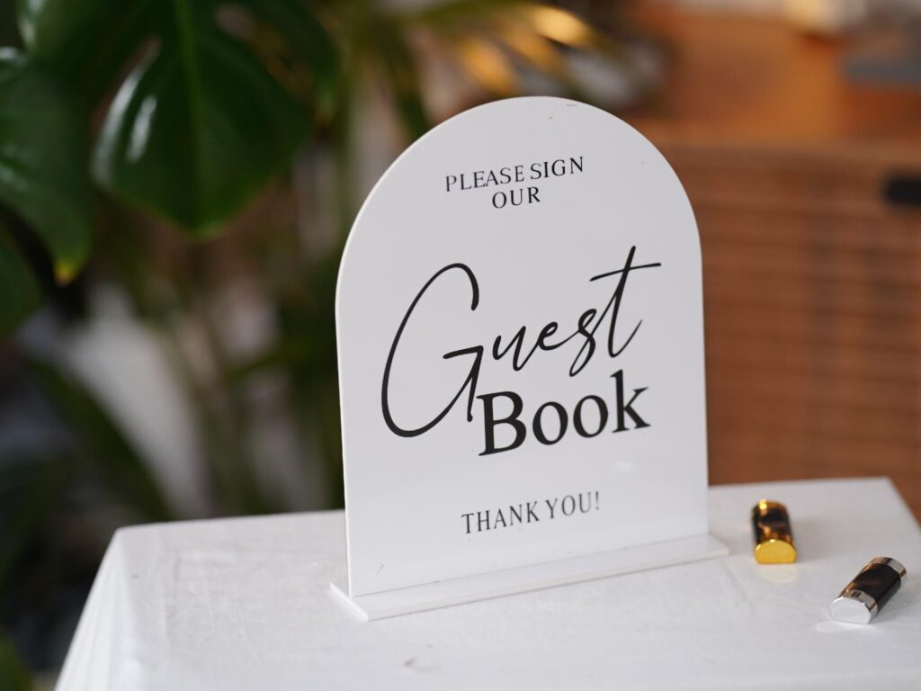 Guest book sign on an acrylic stand for a stationery table