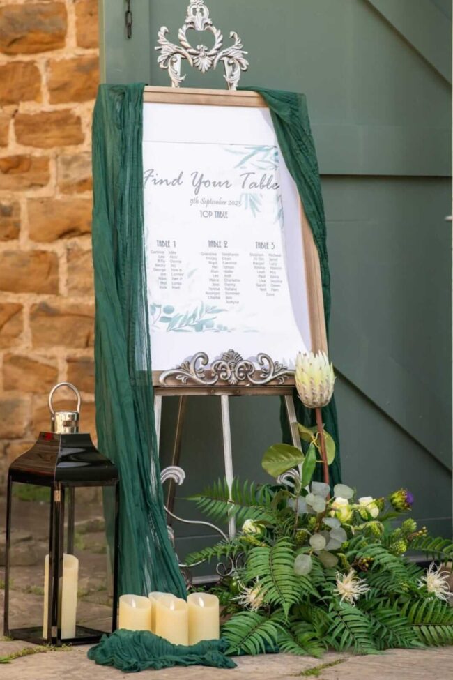 Detail of the antique easel stand base with green drape and foliage styling