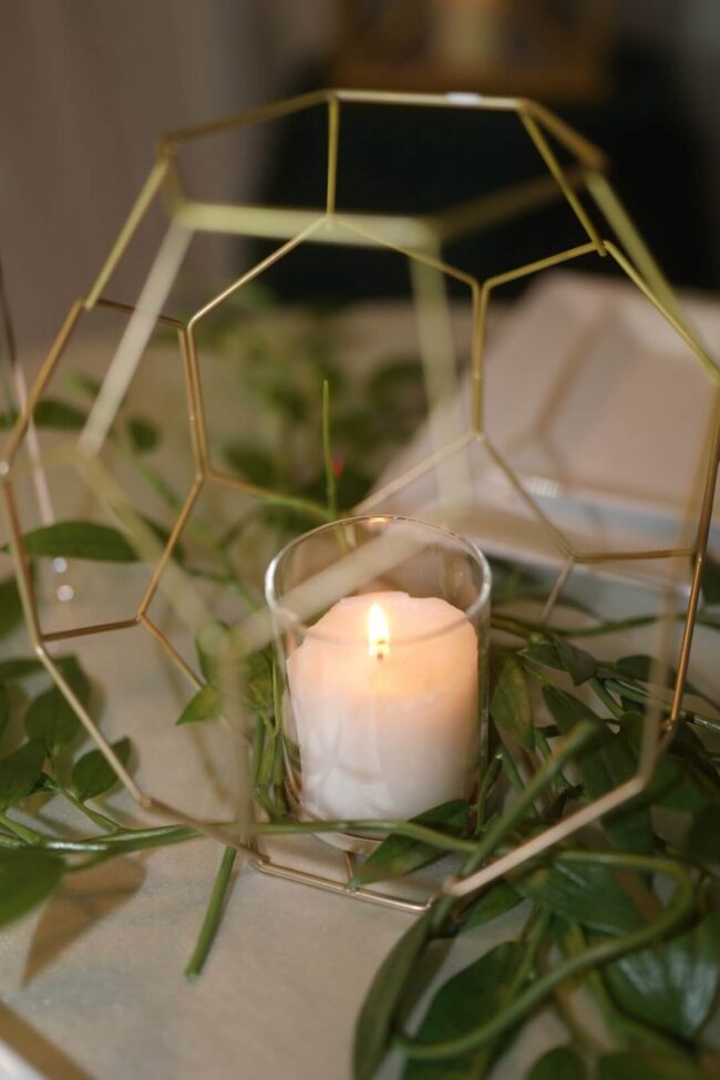 Geometric lantern with gold frame and glass candle holder for warm candlelight