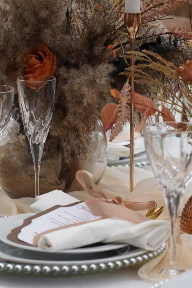 Boho table decor with decorative glass bowl centerpiece, pampas grass, dried flowers and charger plates