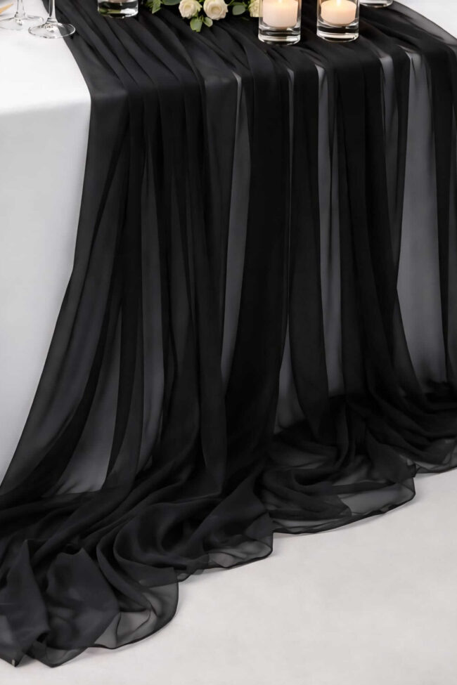 Close-up of black chiffon table runner draped over a dressed event table