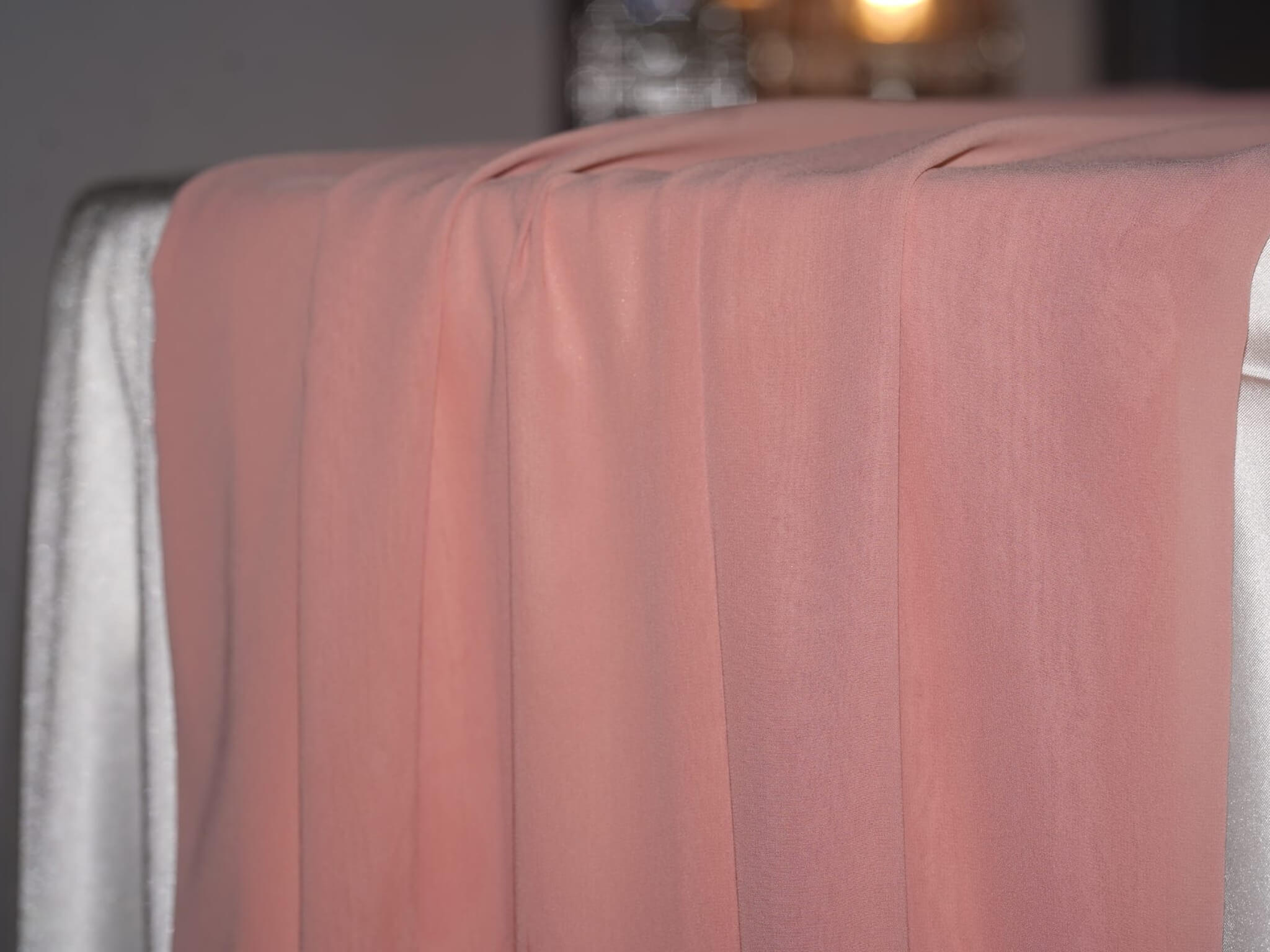 Dusty rose table runner in chiffon fabric shown in a soft draped styling detail