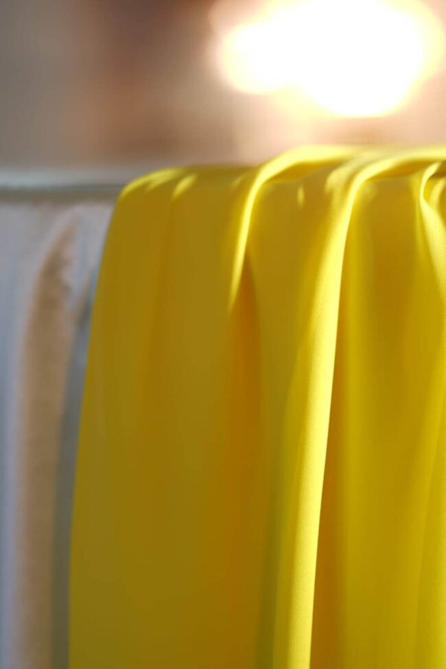 Yellow chiffon runner styled in soft focus as a table centre layer