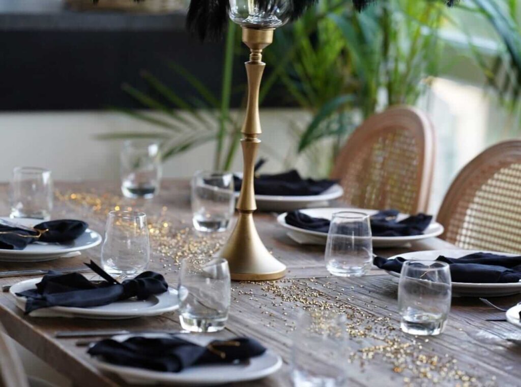 Black napkins styled on wedding table linens with gold centrepiece
