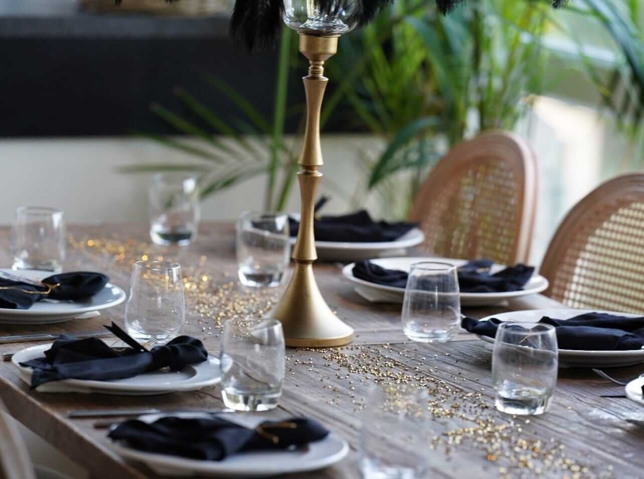 Black napkins styled on wedding table linens with gold centrepiece