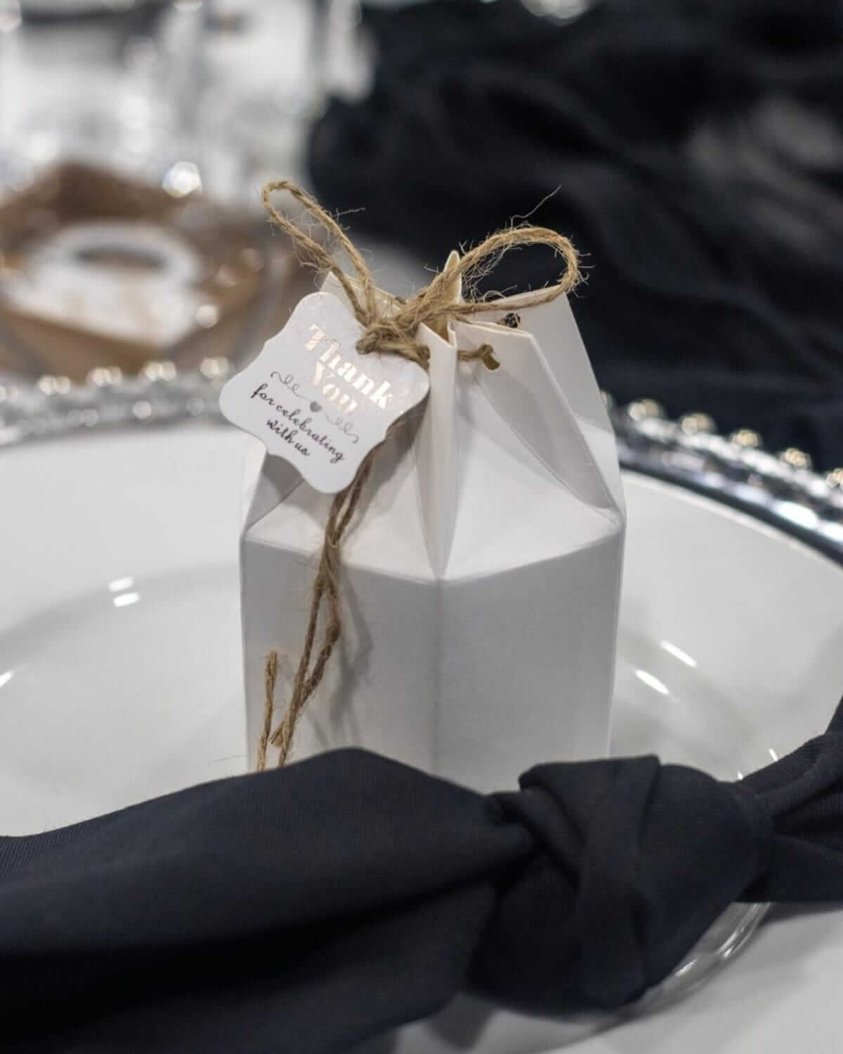 Black cloth napkins tied neatly on a wedding place setting