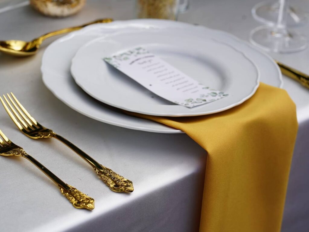 Gold napkins in mustard tone styled on an event table