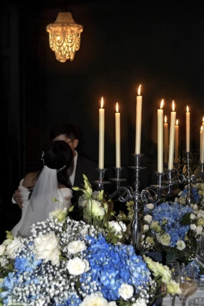 Five-arm stainless steel candelabra with taper candles on a wedding table