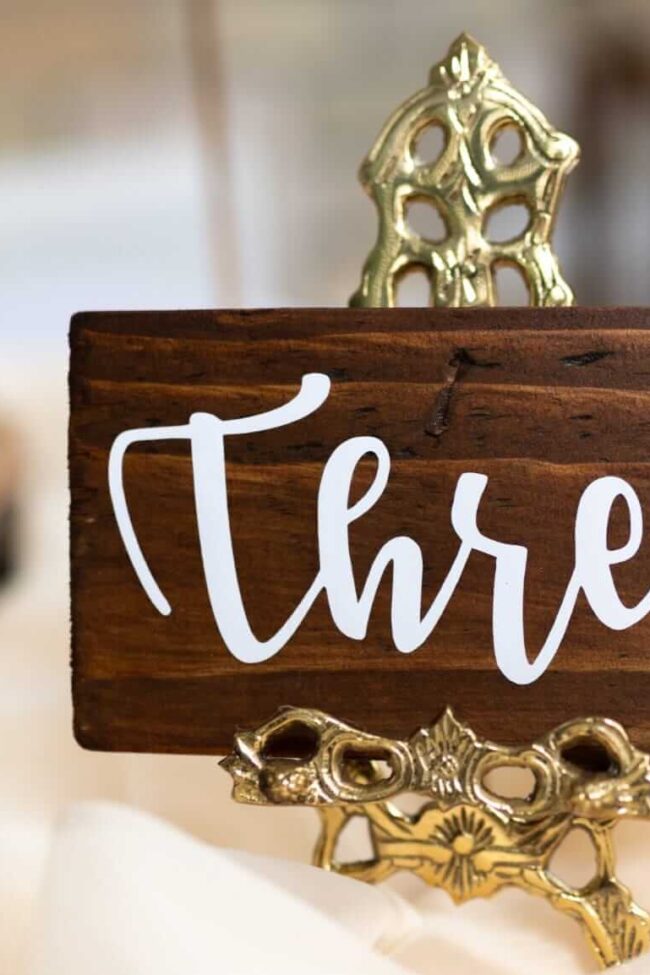 Wooden table number three displayed on a small gold stand