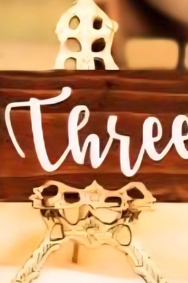 wooden table numbers on a styled table with candles and florals