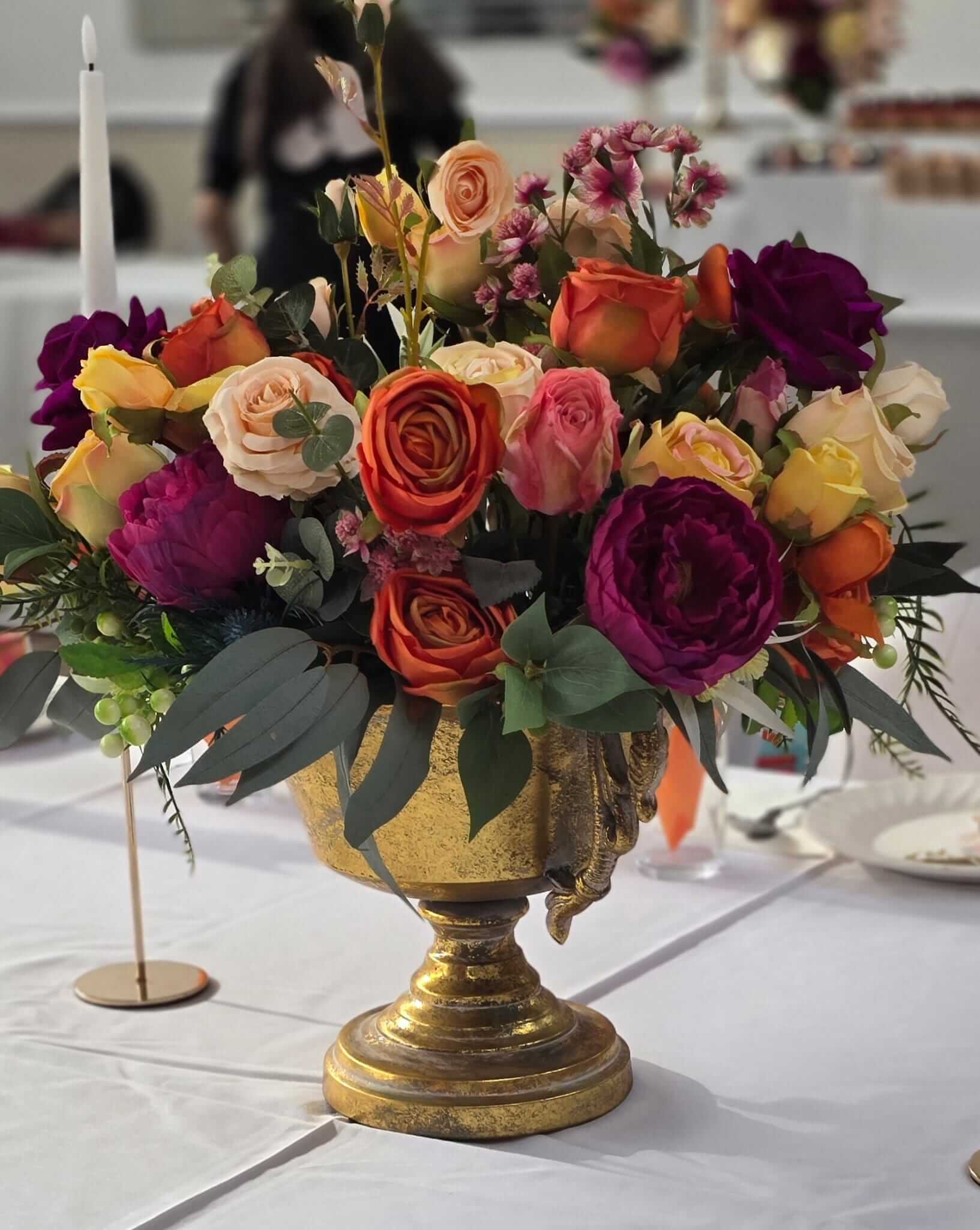 Artificial floral centerpieces styled as a low bespoke design for event tables