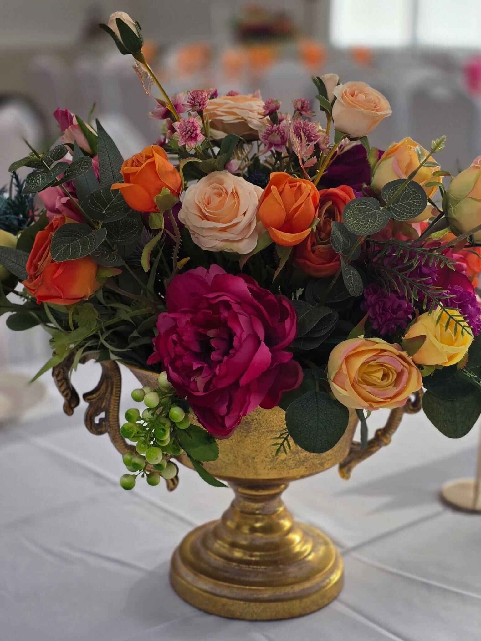 Fake flower centrepieces styled for low wedding and event table décor
