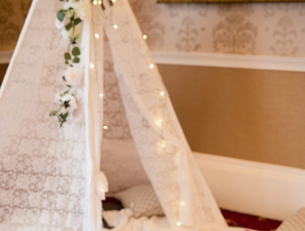 Close view of a lace tipi arch with warm fairy lights