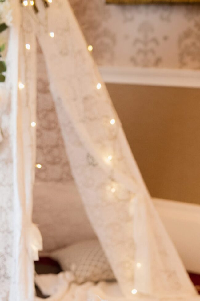 Close view of a lace tipi arch with warm fairy lights
