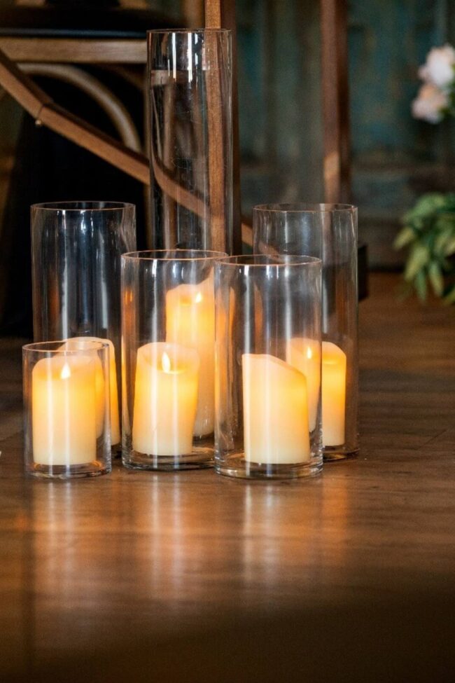 Clear cylinder vases in different heights arranged with candles
