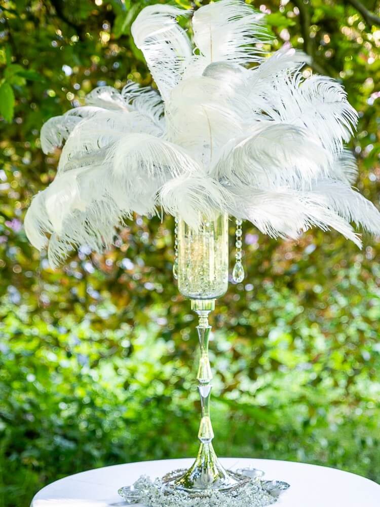 White feather centrepiece on a tall silver stand