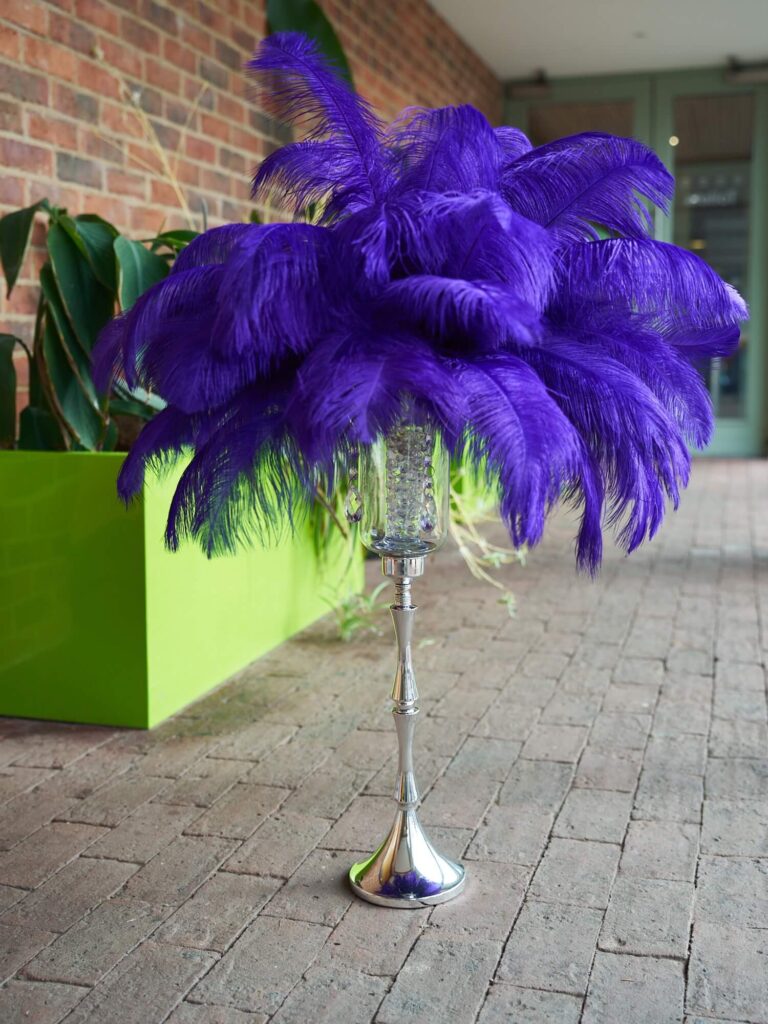 Purple feather centrepiece hire with a tall silver stand