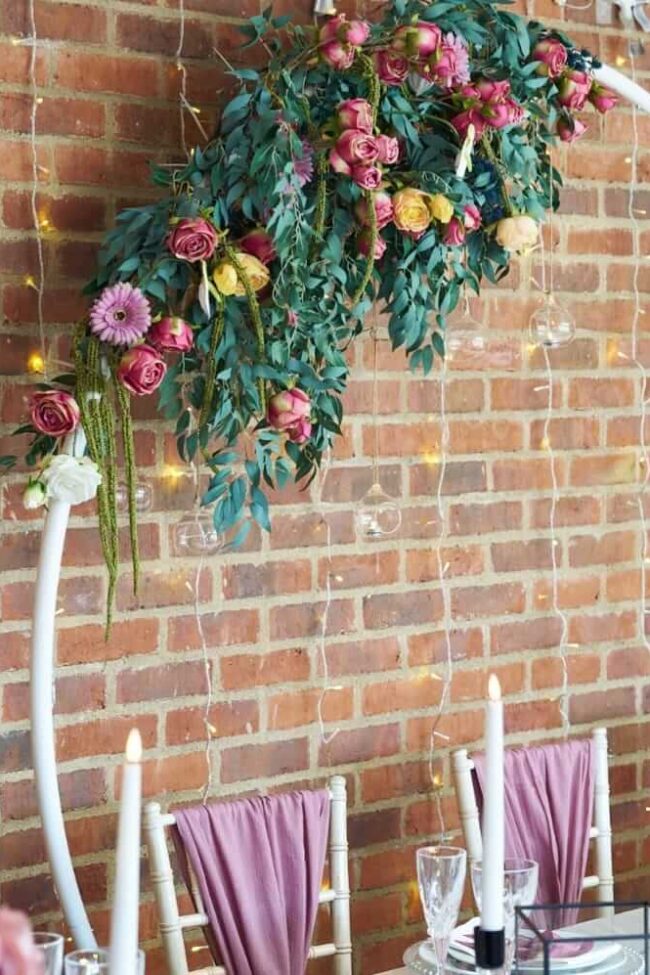2m round arch with pink and yellow flowers arranged across the upper frame